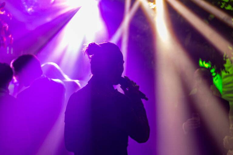 Singer performing backlit by purple lighting