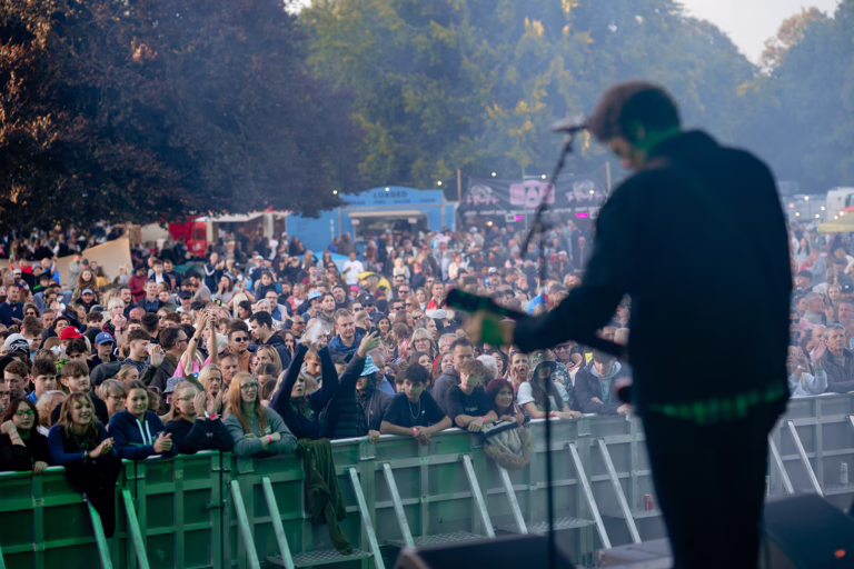 Guitarist performing to crowd on main stage